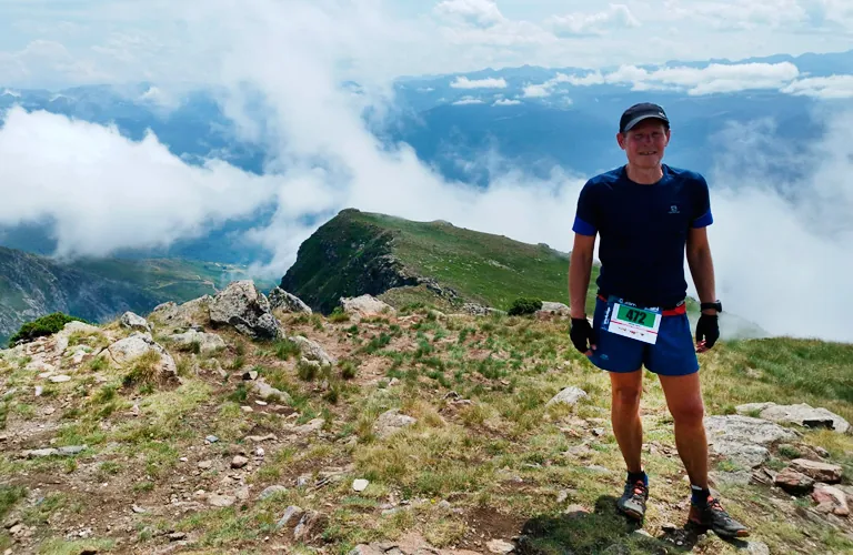 Patrick en trail, au sommet d'une crête de montagne au-dessus des nuages