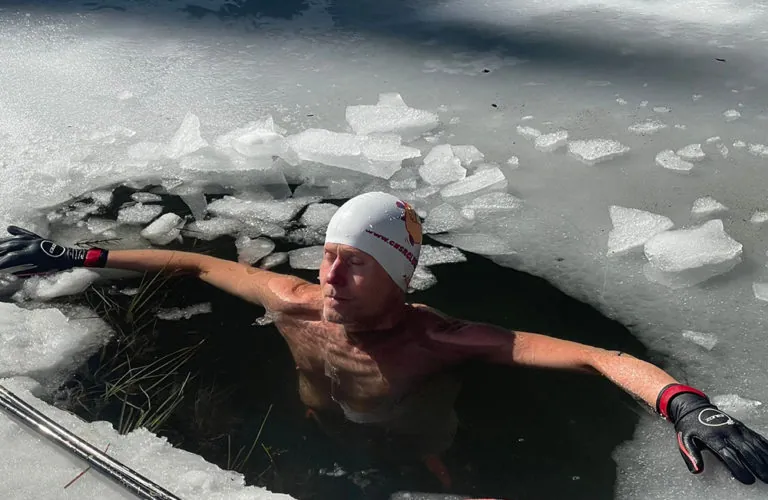 Patrick en immersion dans un trou de glace sur un lac gelé